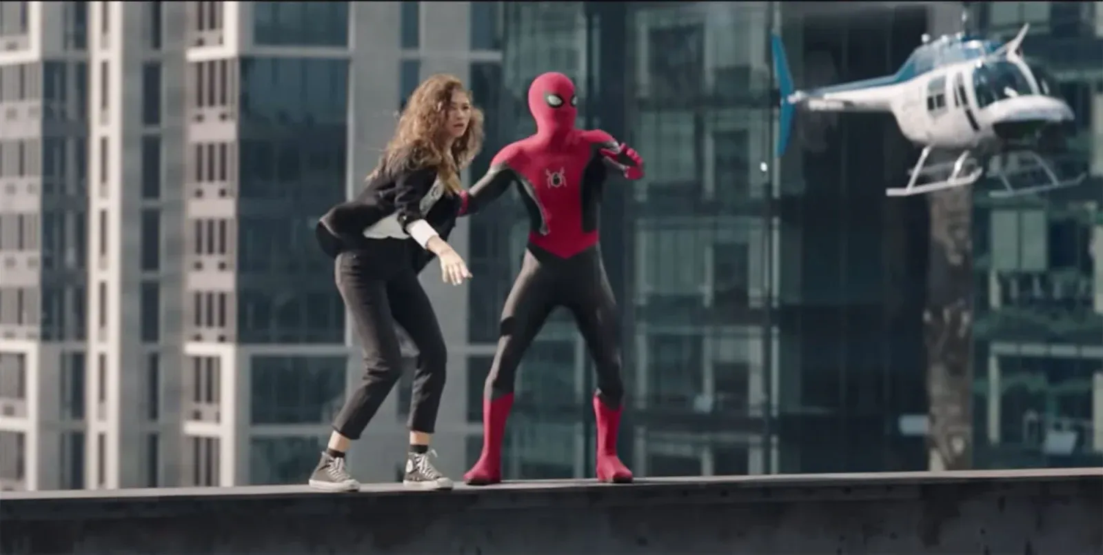 Spiderman and girl (MJ) stand on top of a steel support beam.