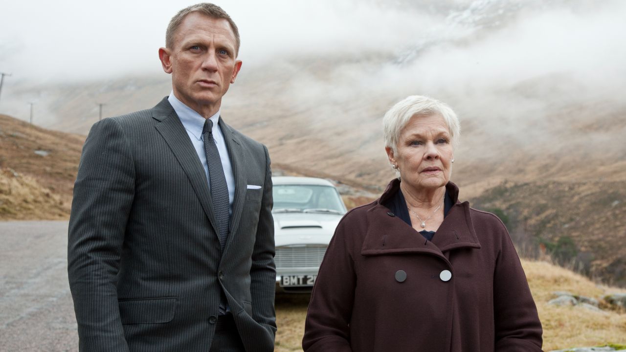 Daniel Craig's James Bond and Dame Judi Dench look off camera in a Scottish moor.