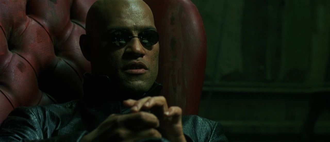 Morpheus in shades sits in his red chair