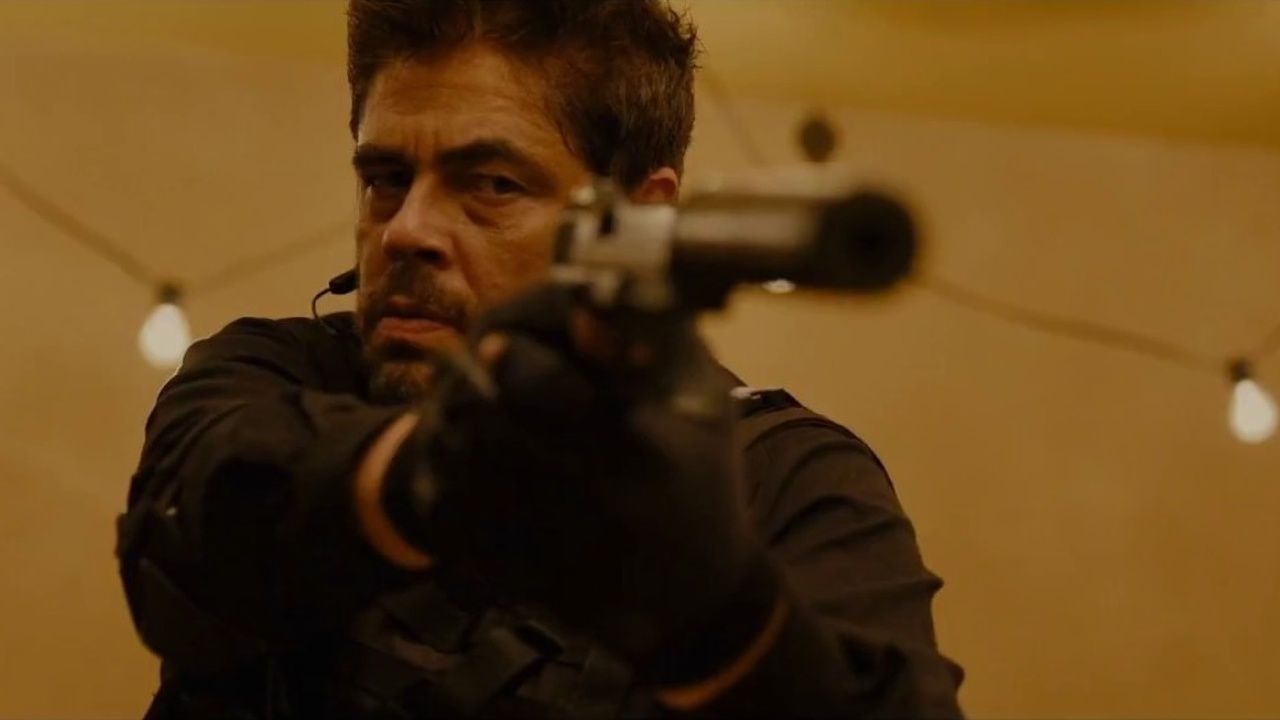 Benicio Del Toro holding a gun in Sicario. 
