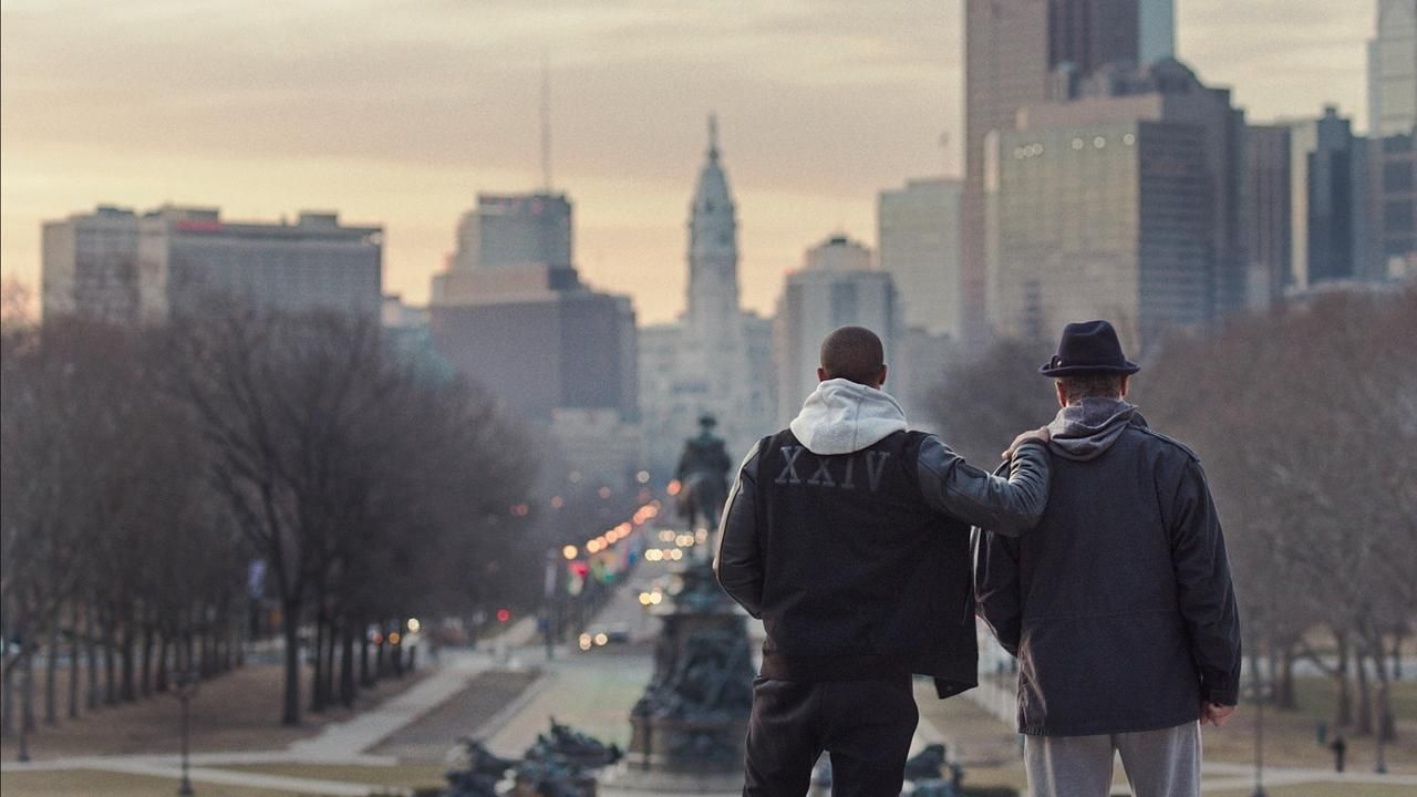 Creed and Rocky stand, looking at the city