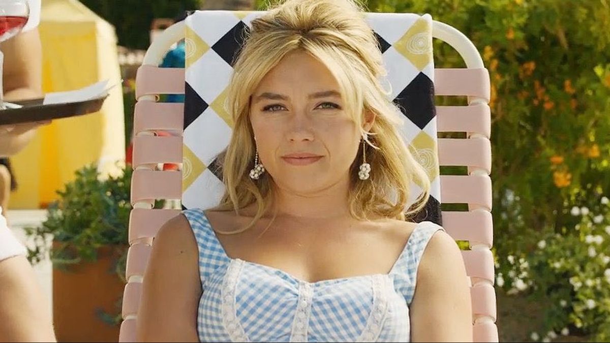 Florence Pugh wears a bathing suit while sitting in a chair in Don't Worry Darling