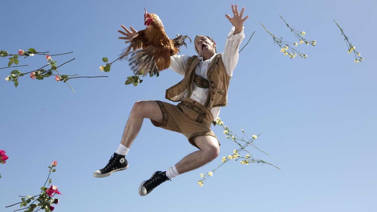 A man flies in the air with chickens and flowers in Jackass 3.5
