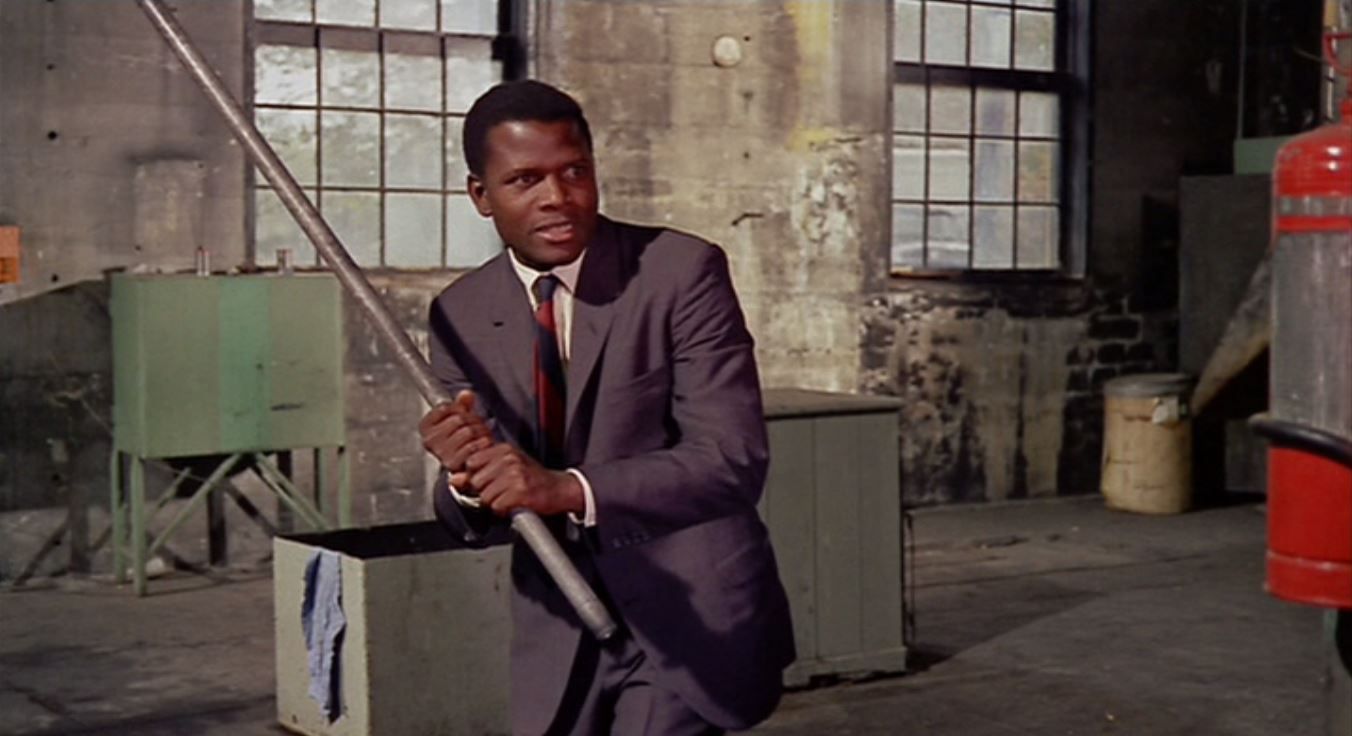 Man in suit holds metal rod.