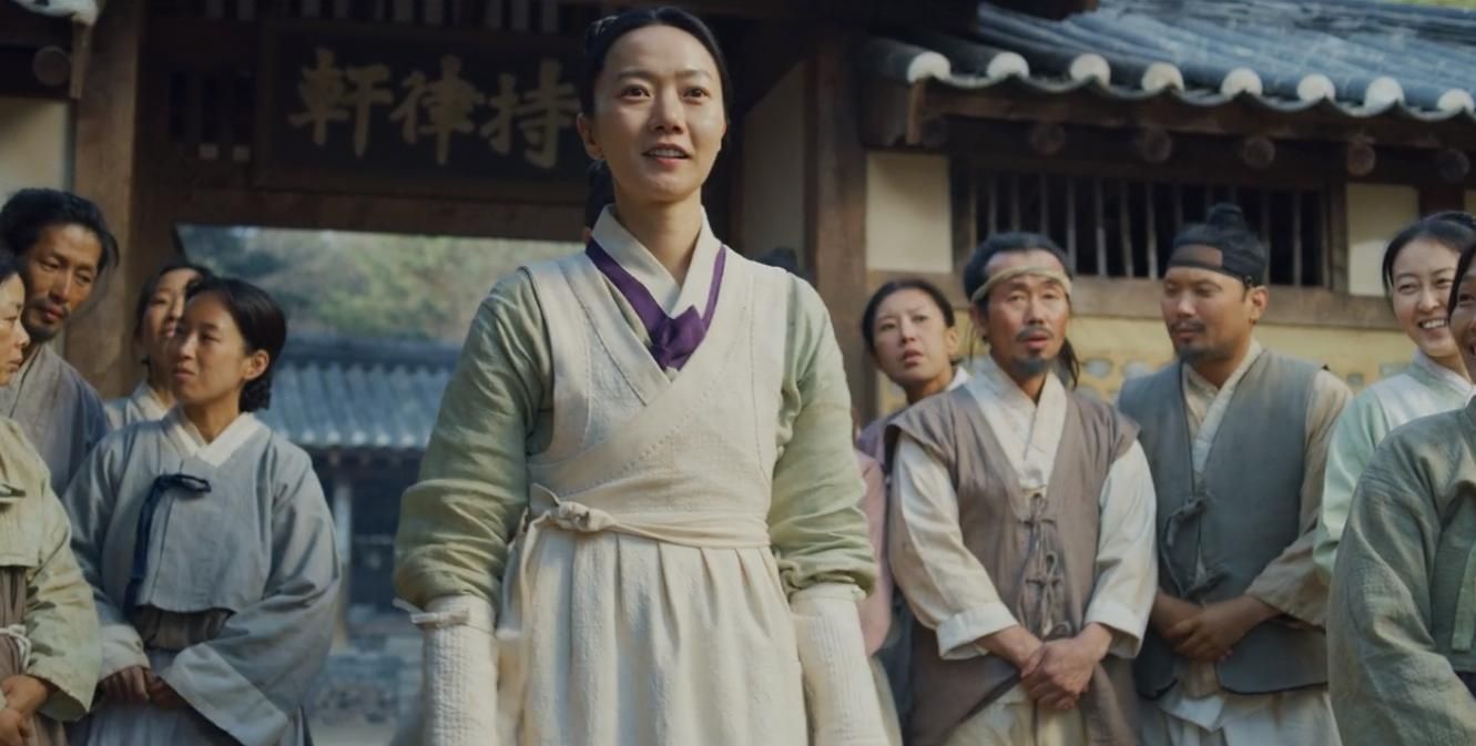 Woman in traditional Korean dress smiles.