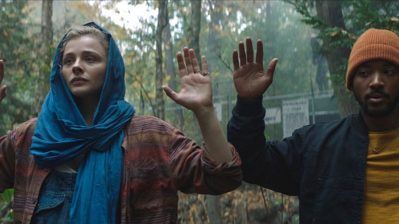 Chloe Grace Moretz and Algee Smith raise their hands in the forest in Mother/Android