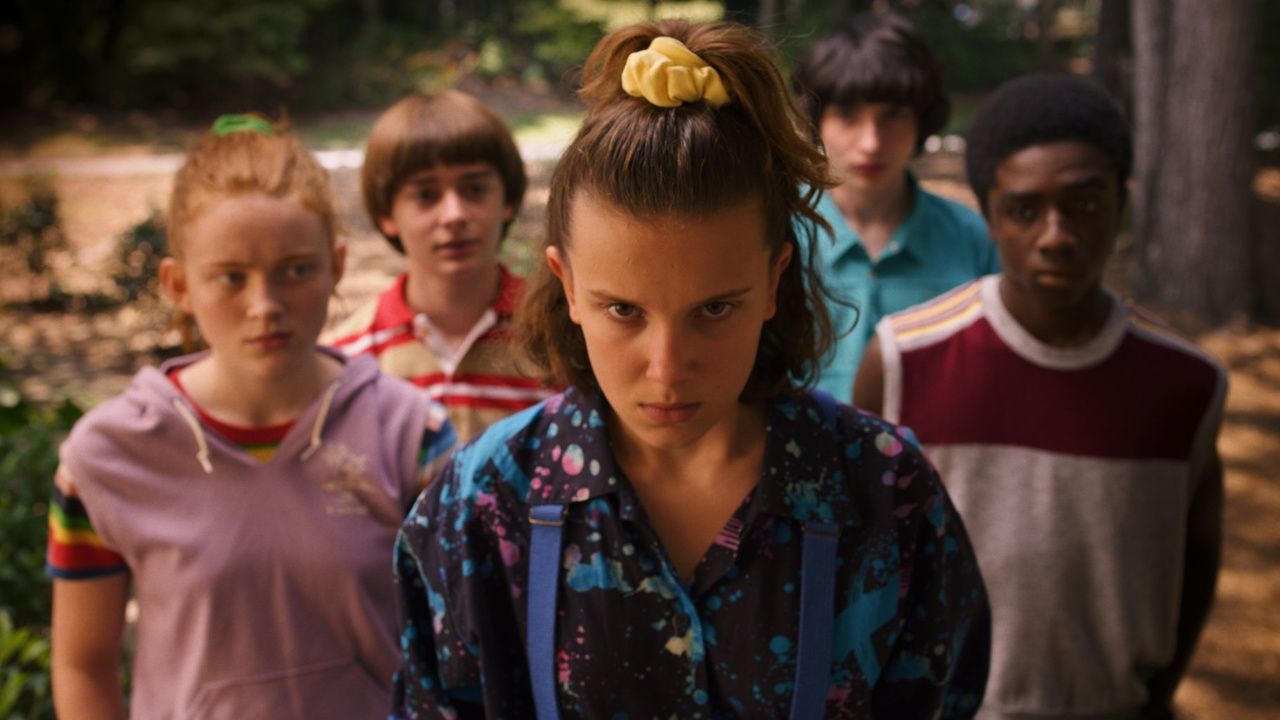 11 stands in front of the rest of the cast, looking angry in Stranger Things