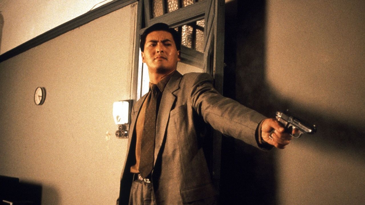 Chow Yun-Fat points a gun out of frame in The Killer
