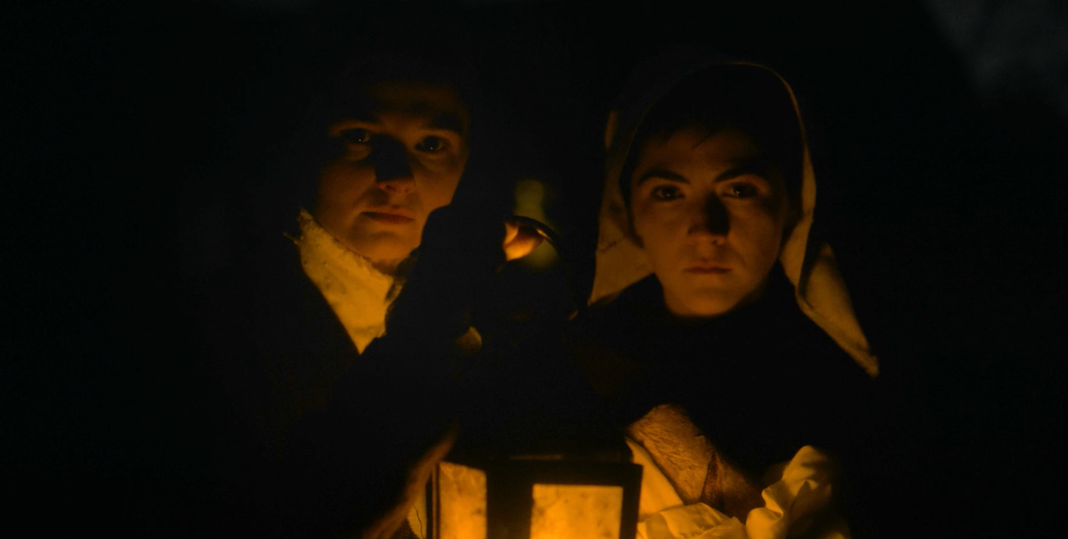 The young lovers hold up their candle lamp in the dark