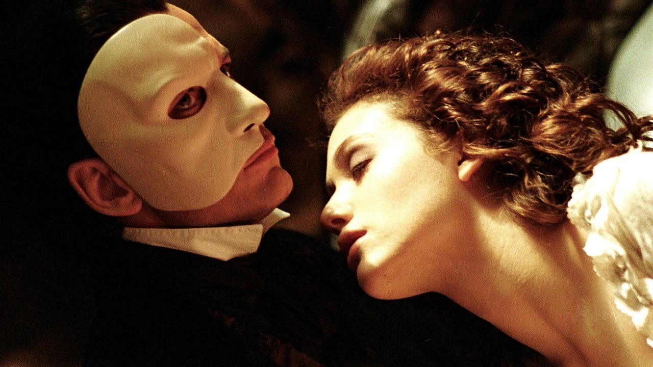 Gerard Butler is the Phantom and cuddles with Emmy Rossum in the Phantom of the Opera