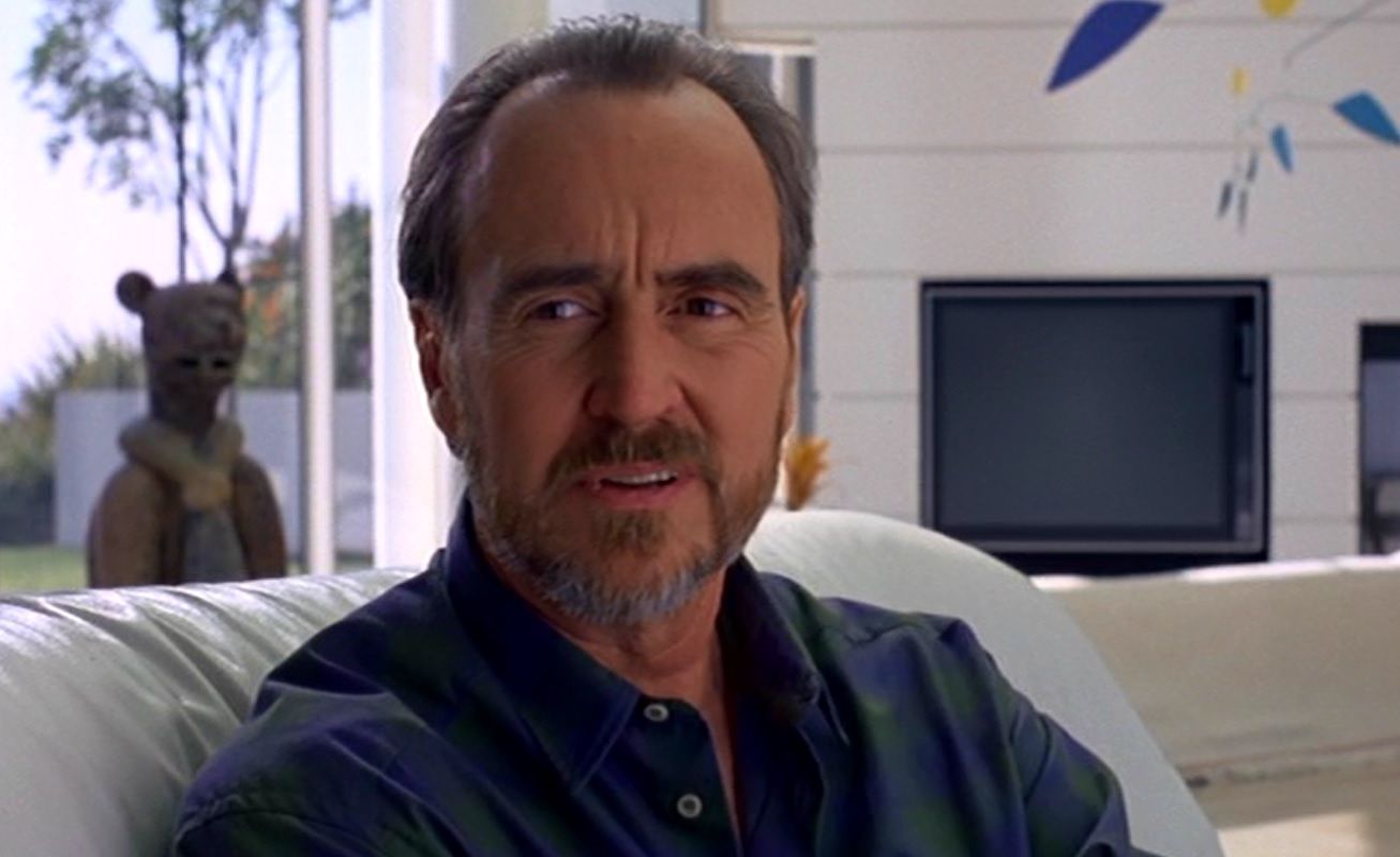 Wes Craven sits on a couch in his film Wes Craven's New Nightmare