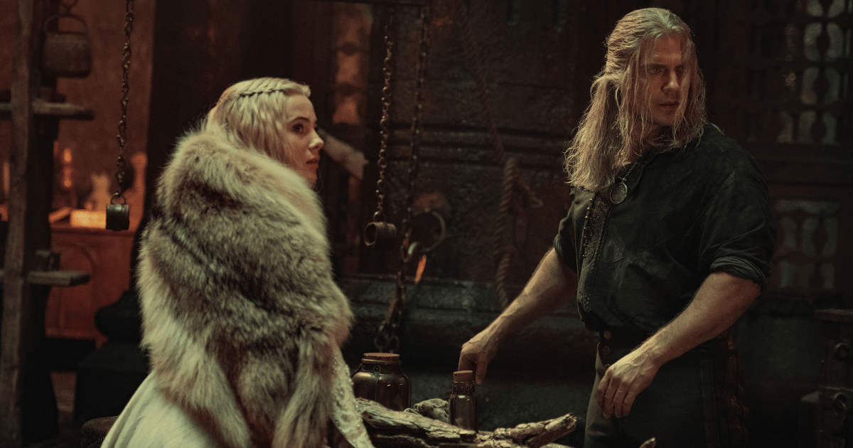 Ciri and Geralt stand across a table from one another looking offscreen.