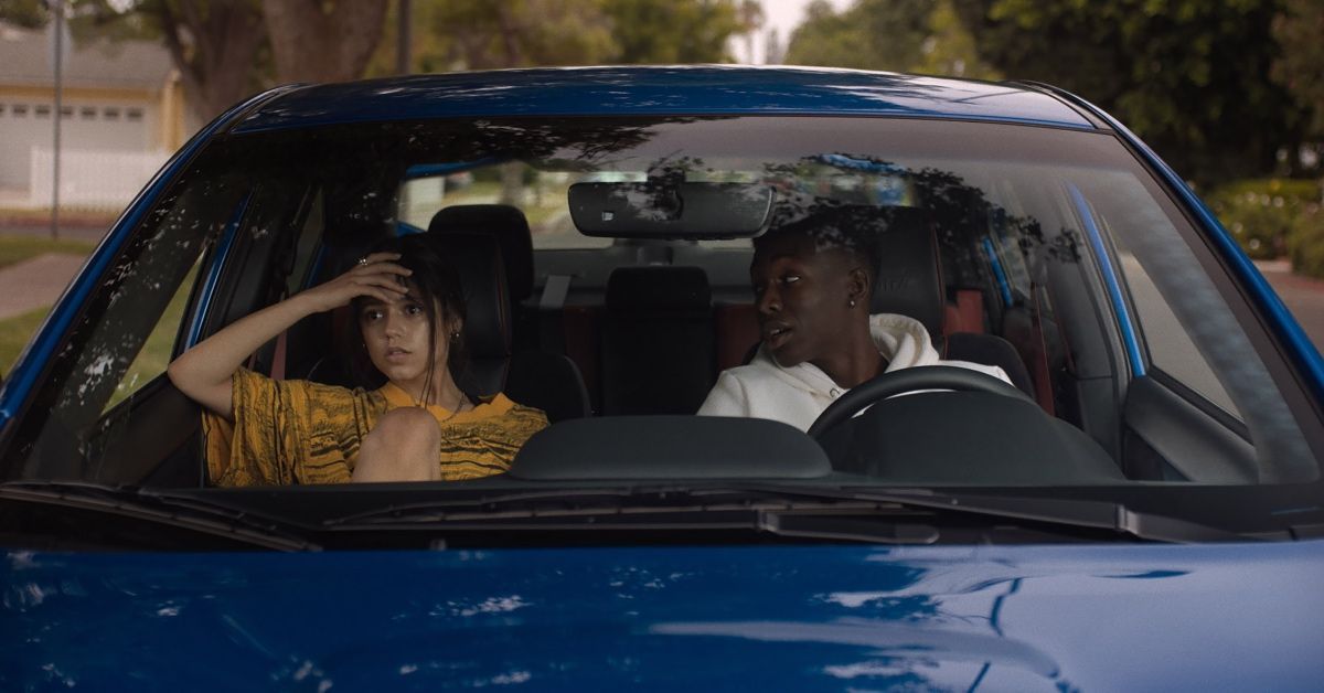 Girl and guy sit in car.