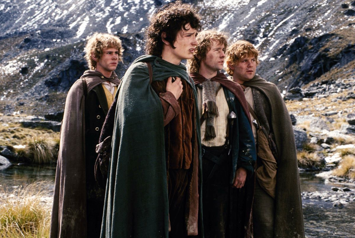 Four hobbits looking off into the distance.