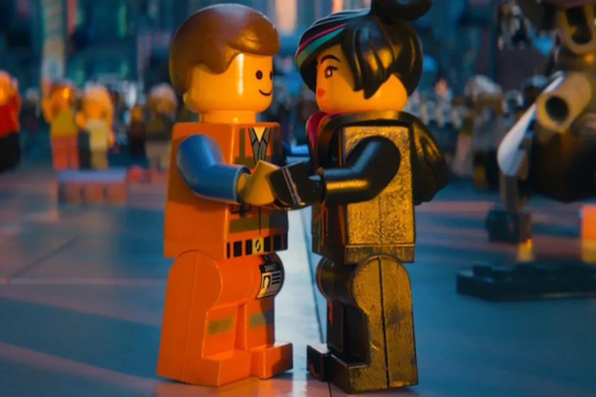 Two Legos hold hands. One is a man and the other a woman.