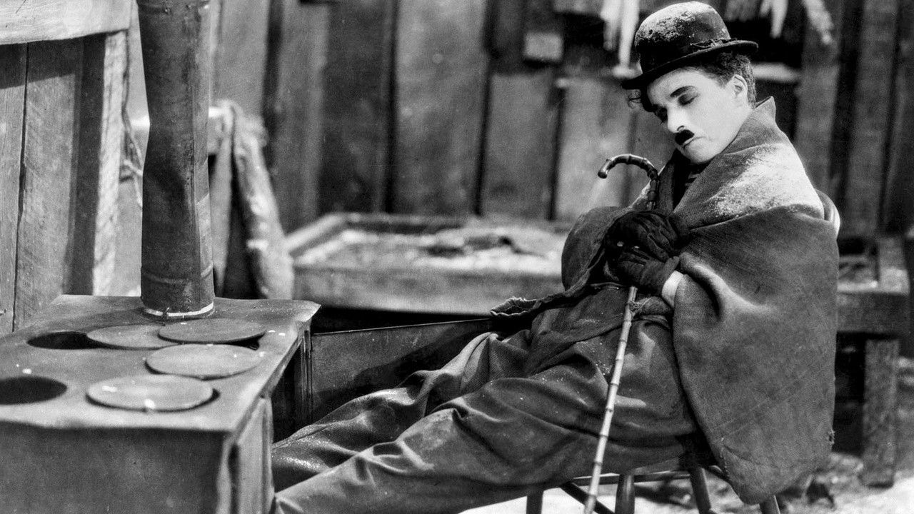 Charlie Chaplin sits on a chair in The Gold Rush