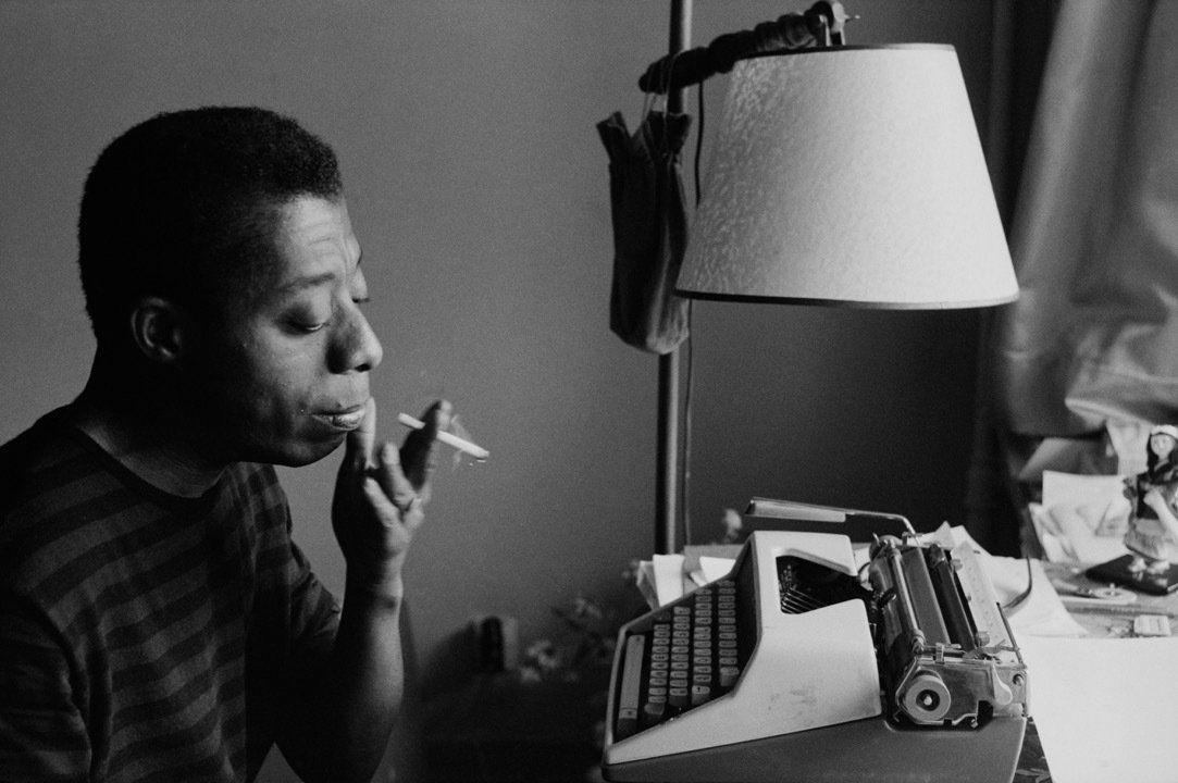 Man sits in front of typewriter smoking.