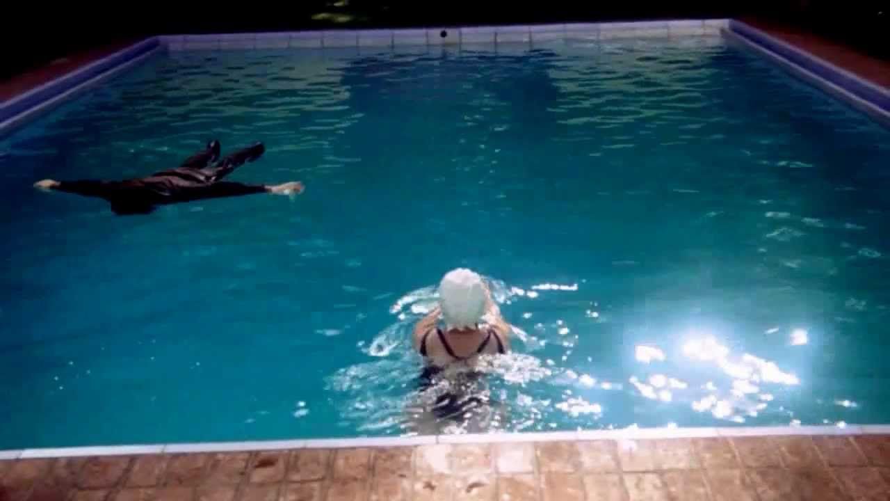 Harold plays dead in the pool while his mother swims around and does laps