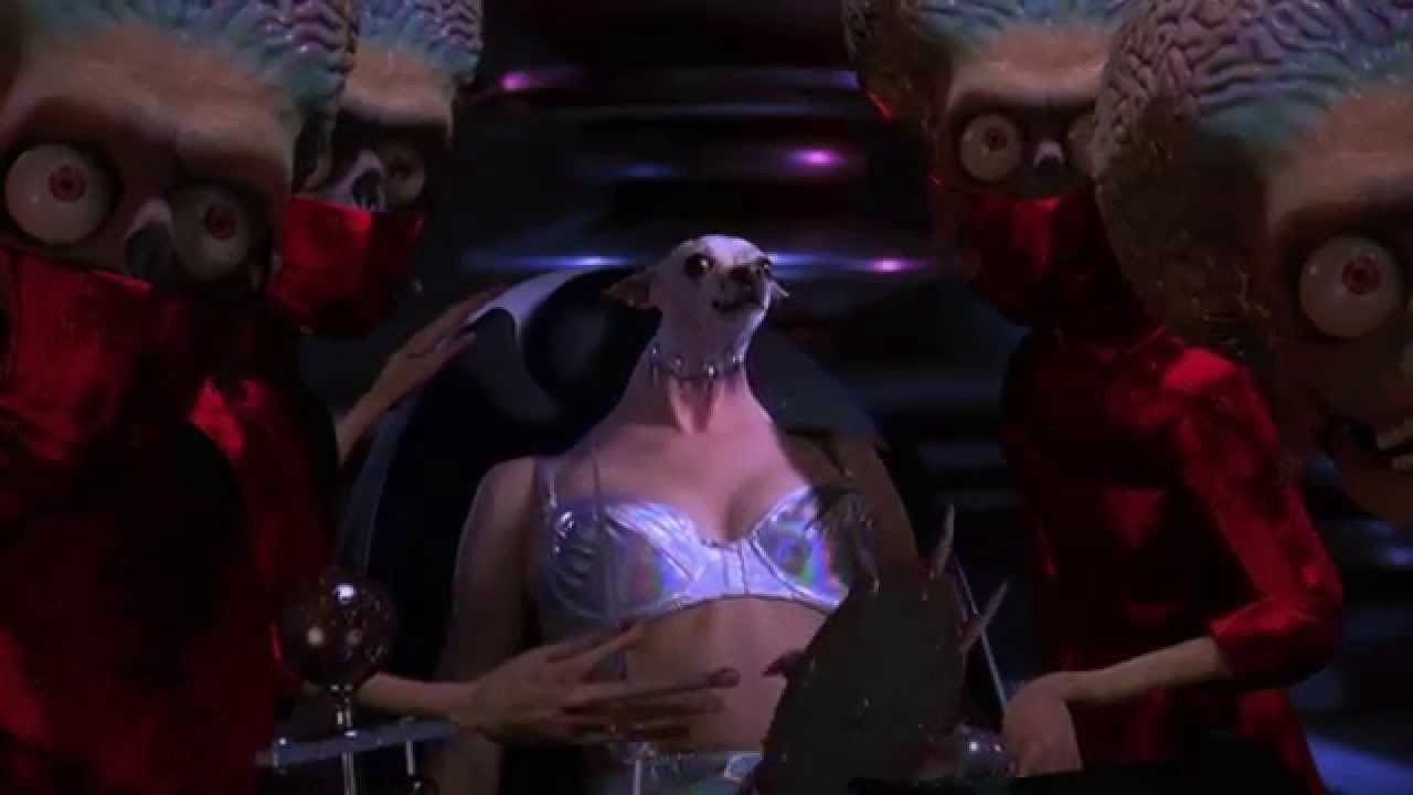 Aliens surround a woman's body who has the head of a Chihuahua