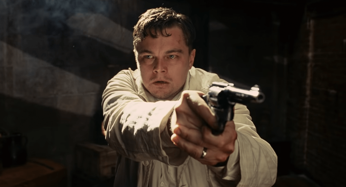 Leonardo DiCaprio looks paranoid while pointing a gun in Shutter Island