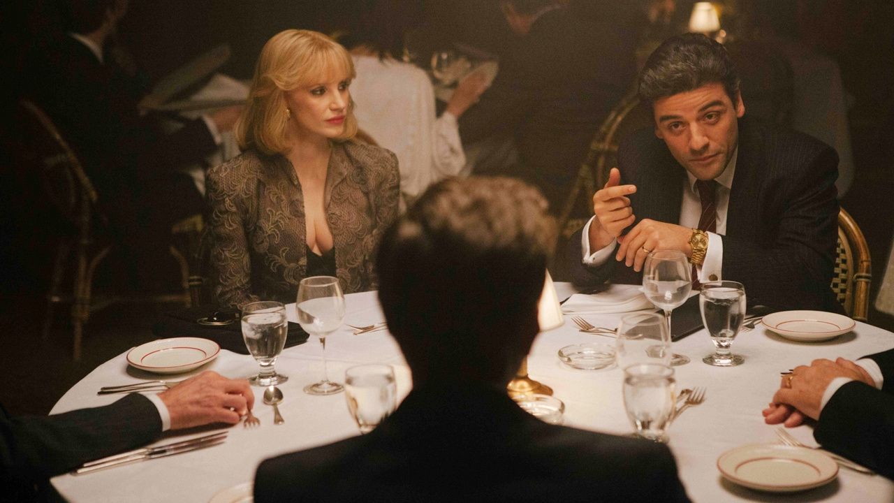 Oscar Isaac sitting at a table in A Most Violent Year. 