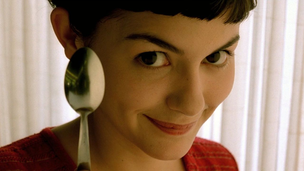 Audrey Tautou as Amelie holding up a spoon and looking directly into the camera