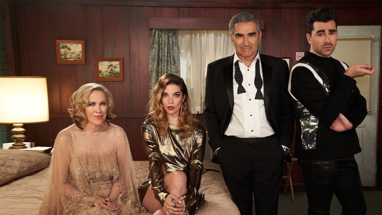 The well-dressed cast of Schitt's Creek in their motel room