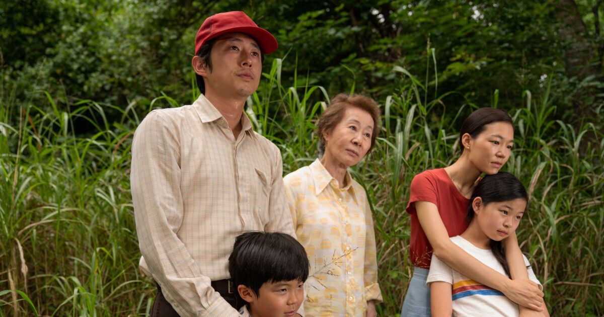 Family stands in fields together.