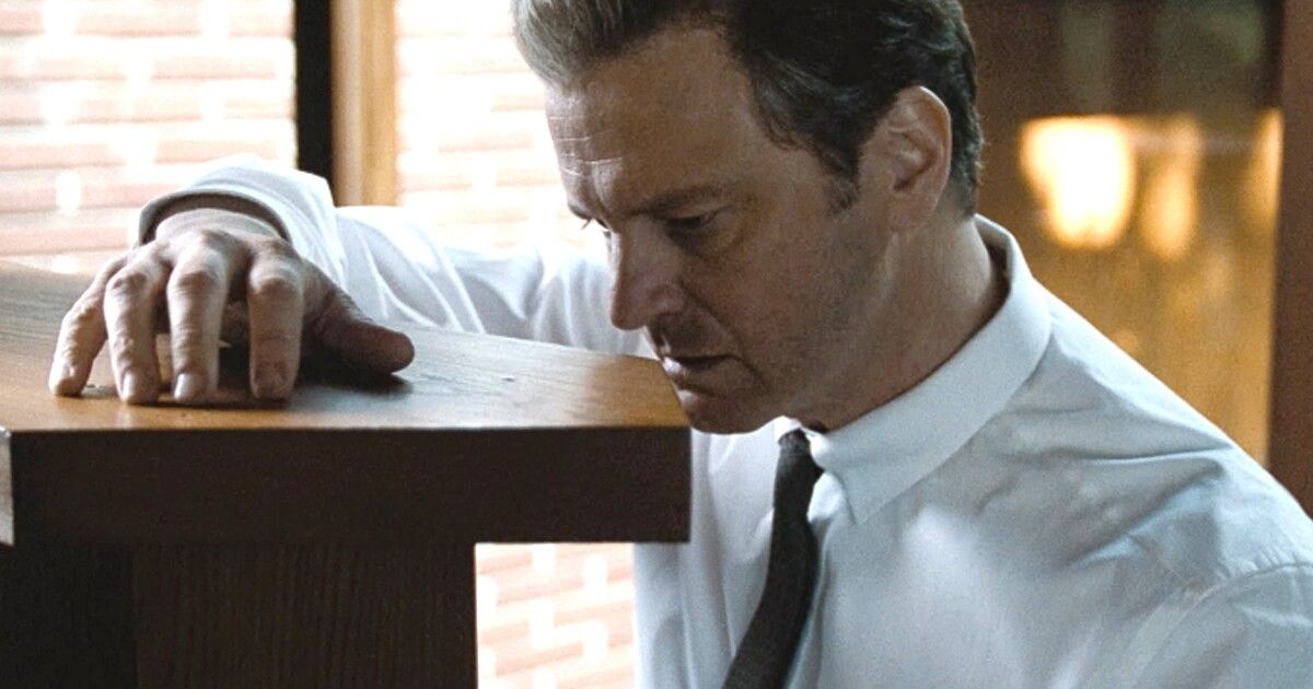 Colin Firth in a white shirt rests his hand on a shelf in A Single Man