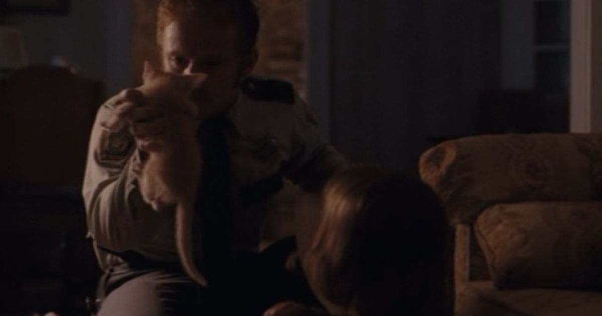Foster holds up a kitten in Aint Them Bodies Saints