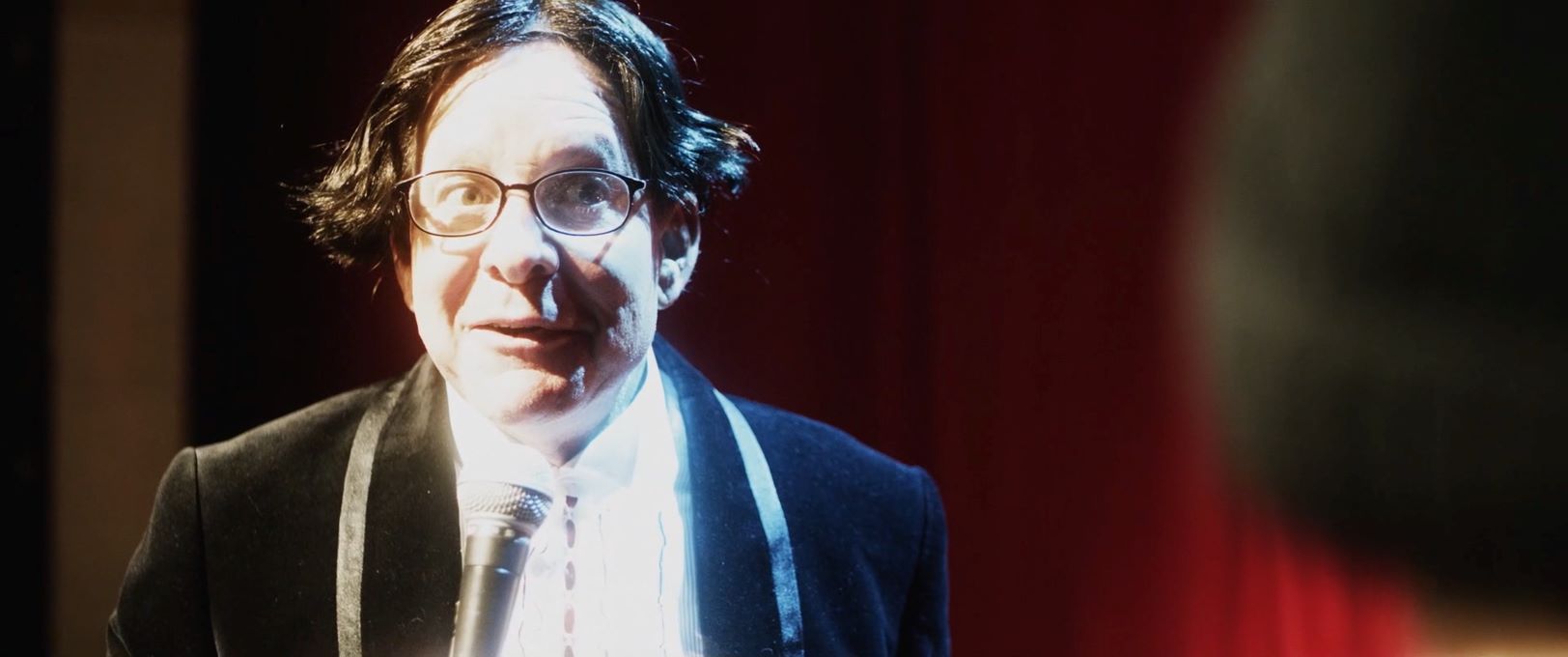 Guttenberg in a bad wig in the spotlight performing