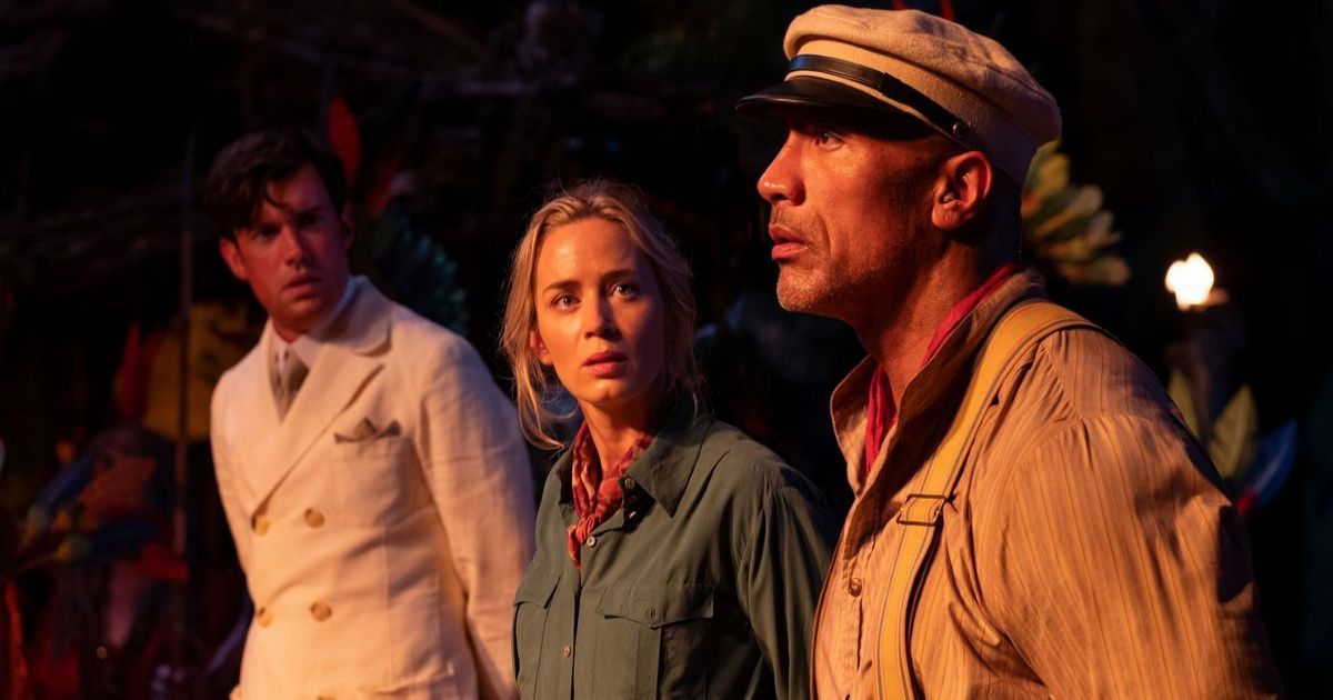 Emily Blunt and Captain The Rock stand by a fire in Jungle Cruise