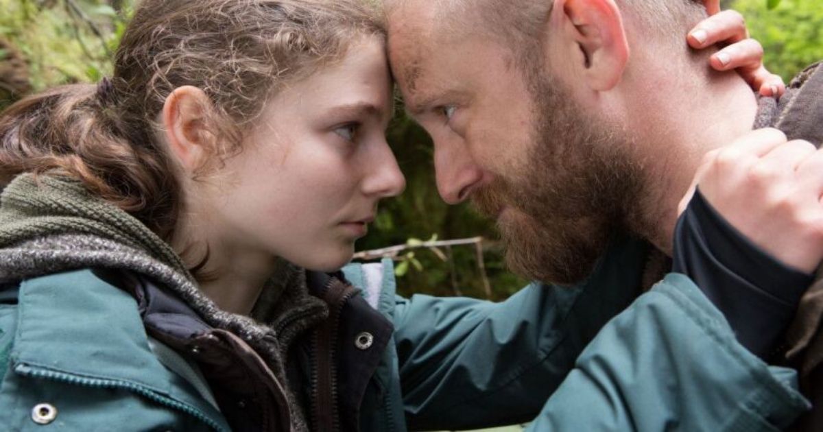 Foster and Thomasin Mackenzie hug close in the woods of Leave No Trace