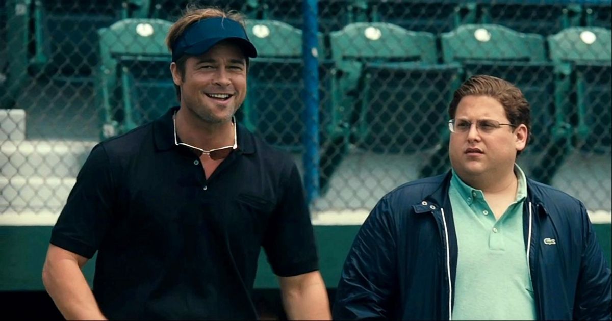 Brad Pitt and Jonah Hill talk at a baseball field in Moneyball