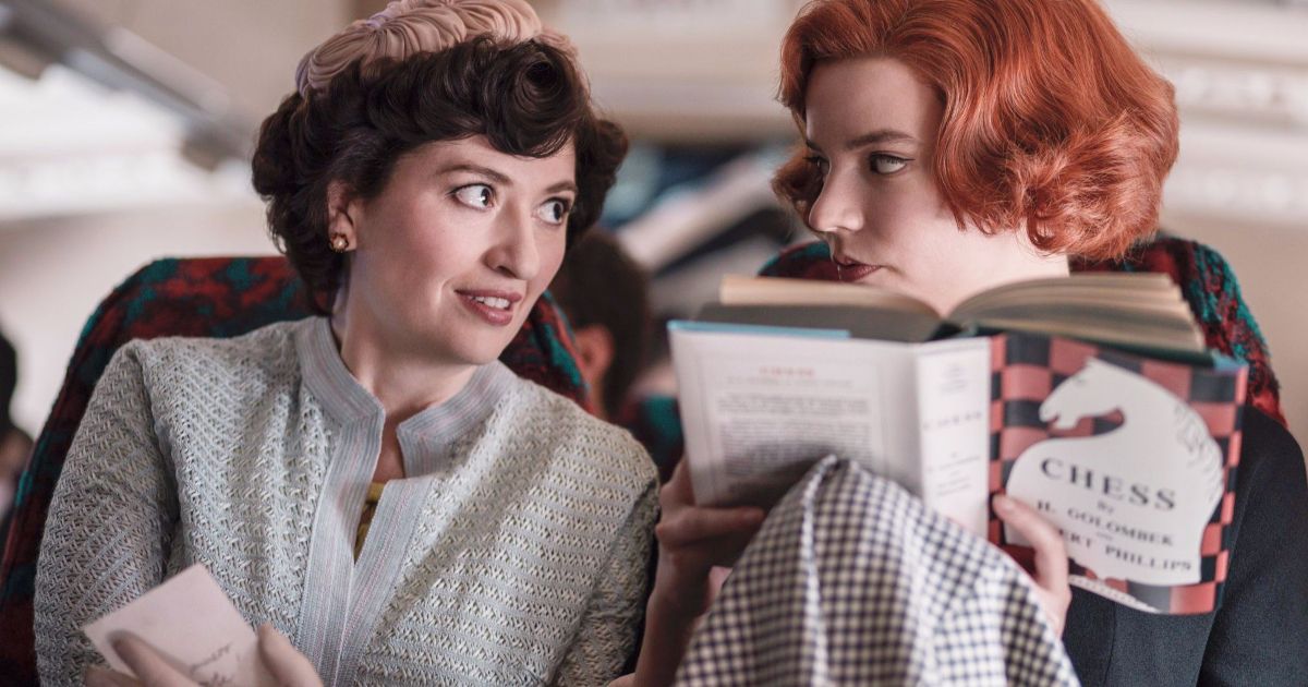 Anya Taylor-Joy reads a chess book next to a woman in The Queen's Gambit