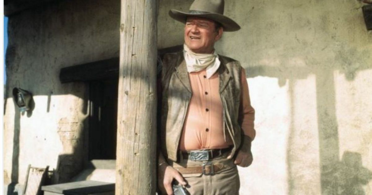 John Wayne as a cowboy on the porch in Rio Lobo