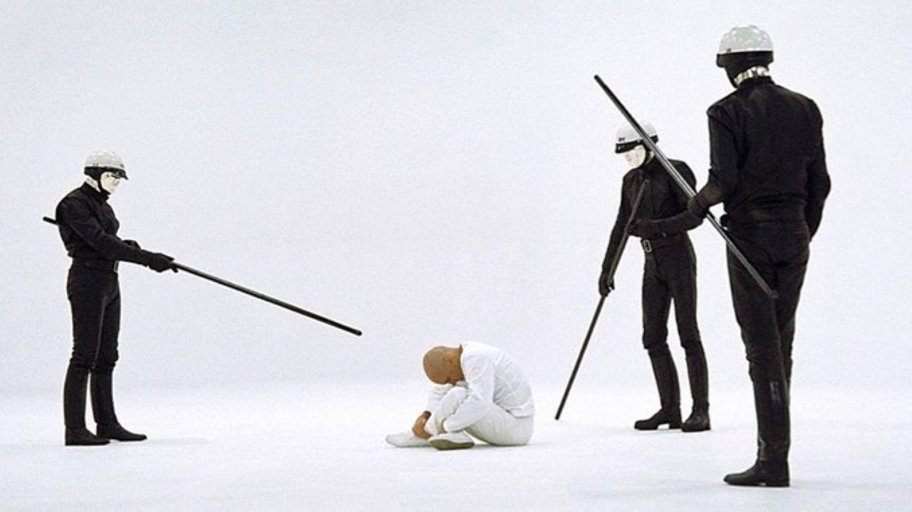 THX-1138 is surrounded by robot cops with prods