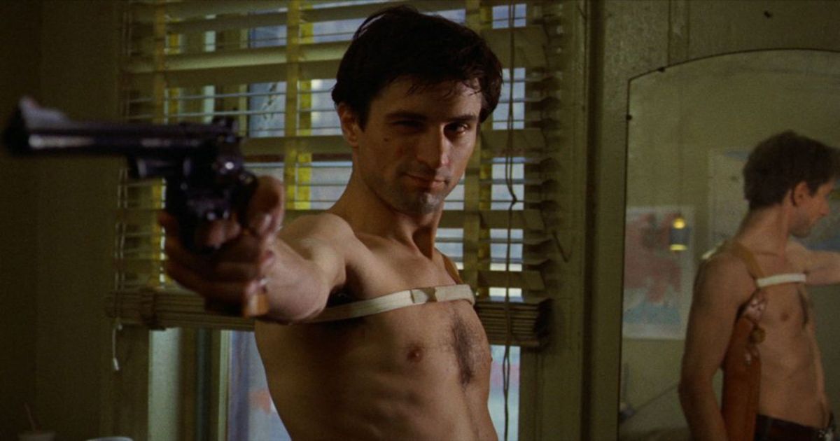 Robert De Niro shirtless and pointing a gun off screen in Taxi Driver 
