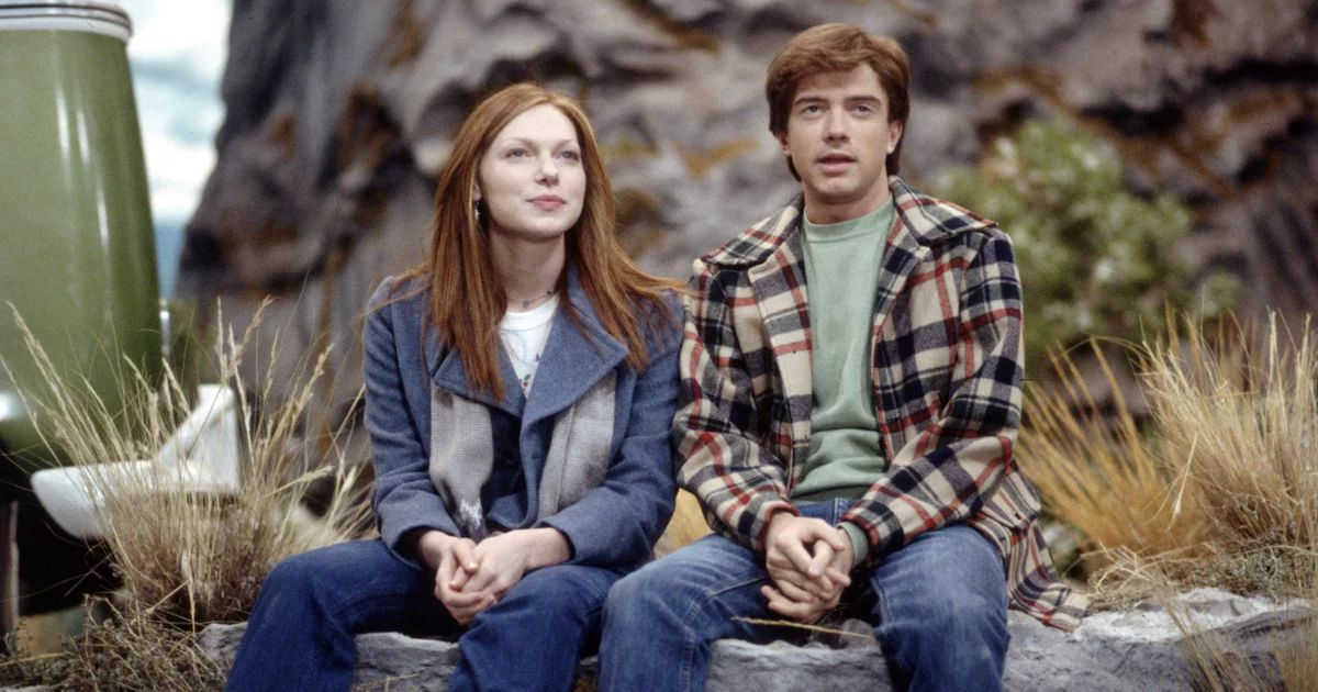 Eric and Donna sit on a rock in That 70s Show 