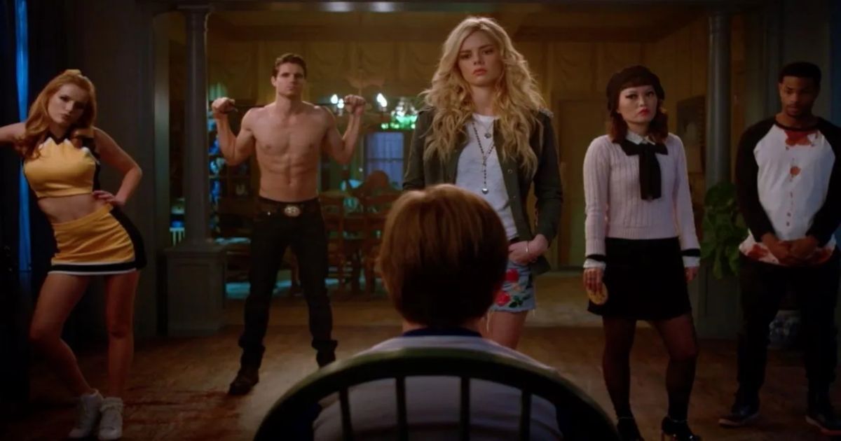 A man in a chair looks at four women and a shirtless guy in The Babysitter
