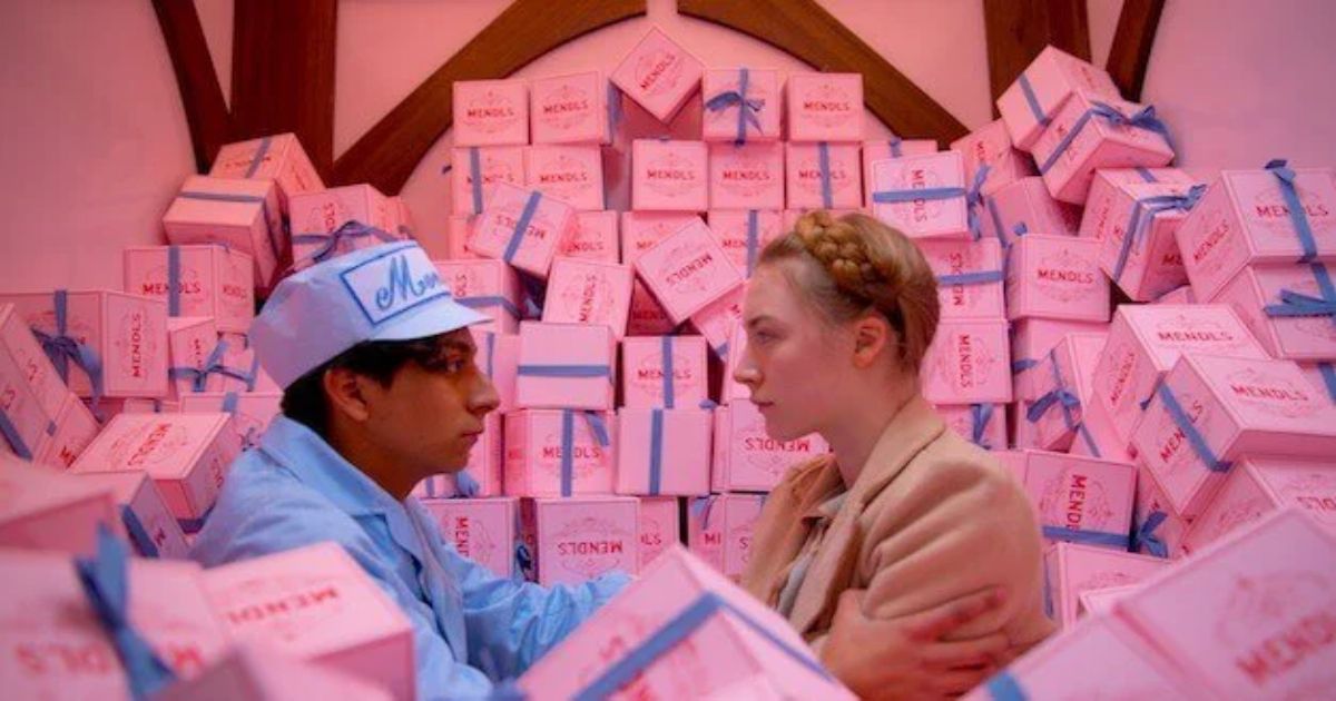 Os dois jovens na sala de correspondência cheia de caixas cor-de-rosa no Grande Hotel Budapeste