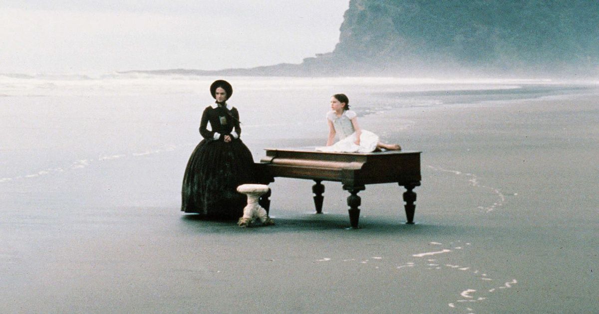 Holly Hunter stand by a piano on the beach in The Piano