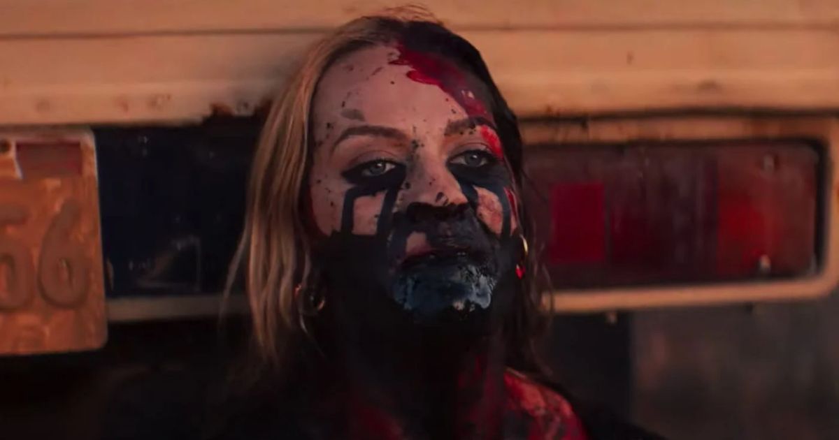 The Seed star Lucy Martin covered in blood and black fluid against a truck