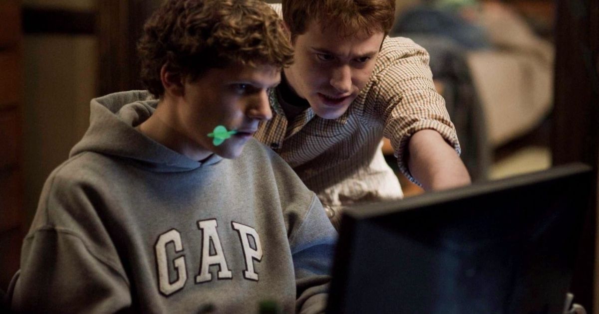 Eisenberg chewing a pen while on the laptop in The Social Network