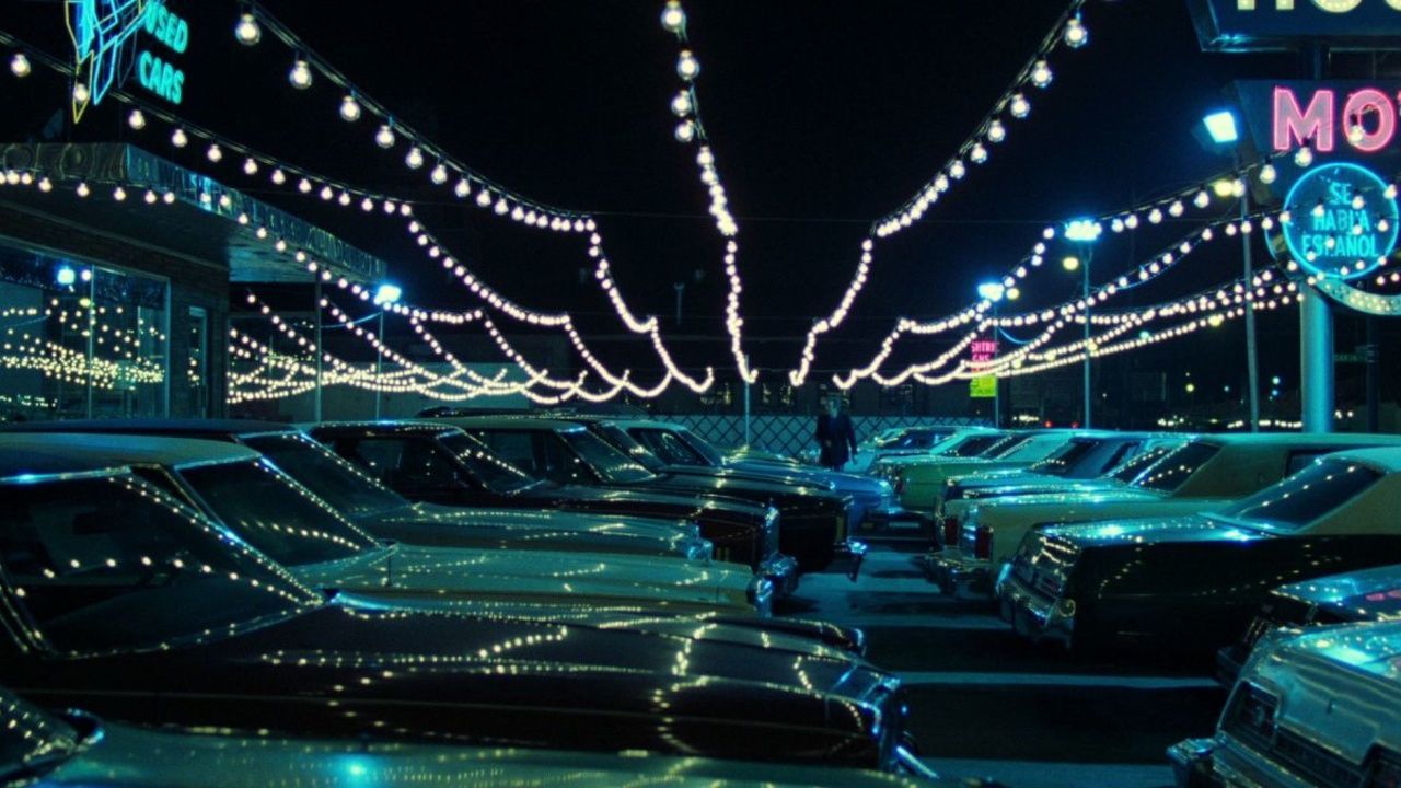 A car lot filled with neon lights and reflections in the movie Thief