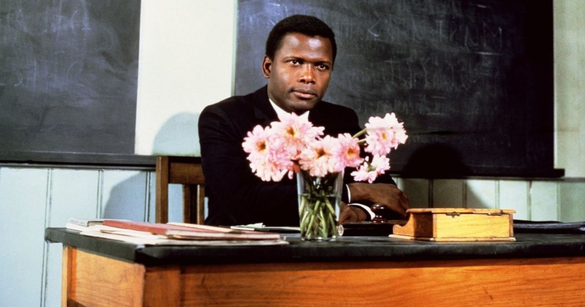 Poitier con un jarrón de flores rosas en el escritorio del profesor en To Sir With Love