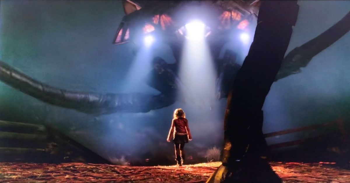 Una niña se para debajo de una nave espacial en War of the Worlds