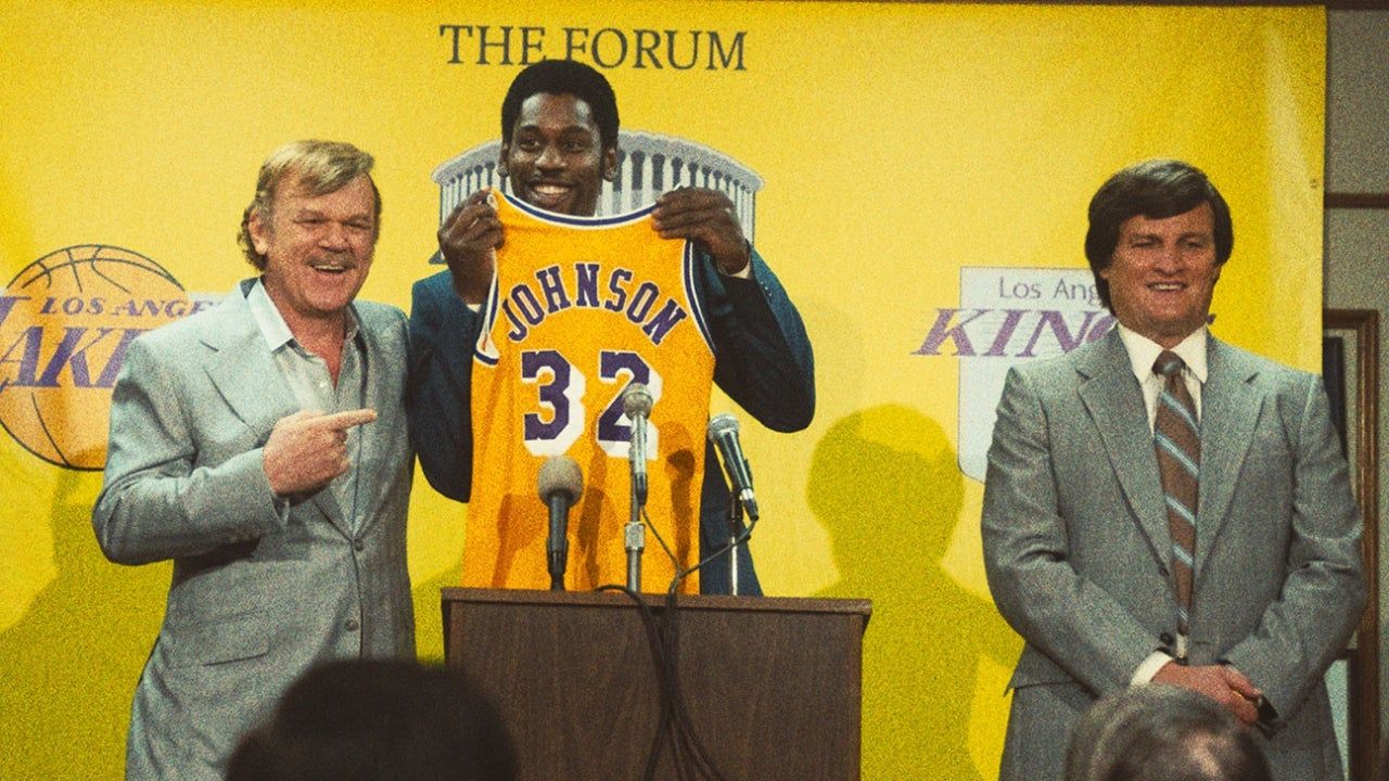 Magic holds up his new Lakers jersey at a press conference in Winning Time