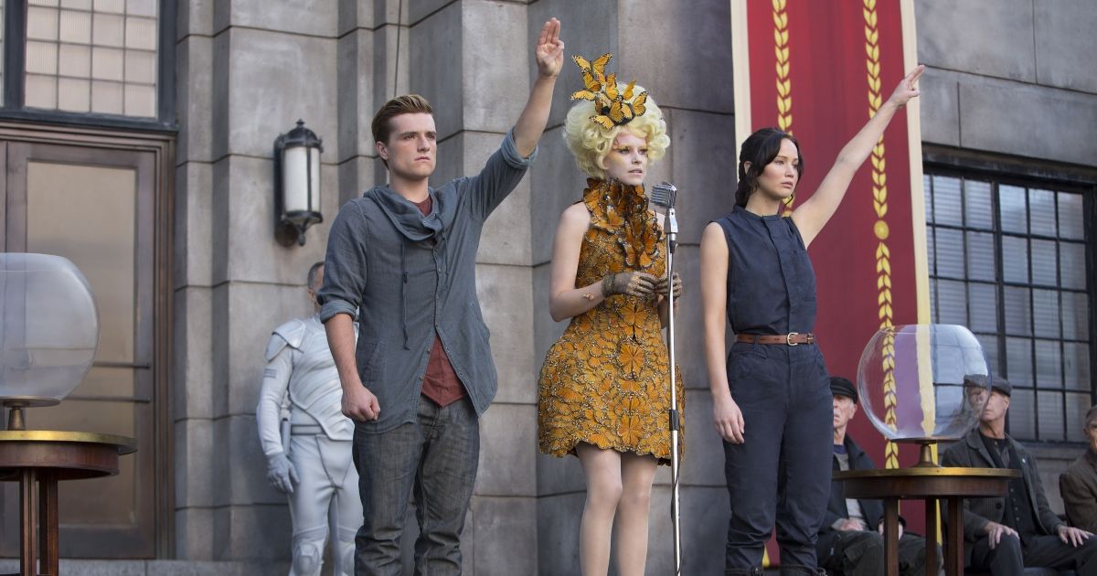 Katniss and Peeta being chosen for the next Hunger Games, giving the crowd a three finger salute in silent rebellion.