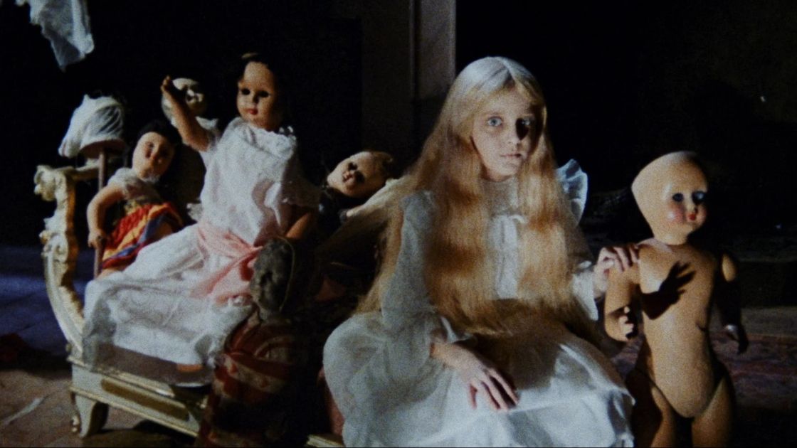 Child sitting with dolls in Kill, Baby, Kill. 